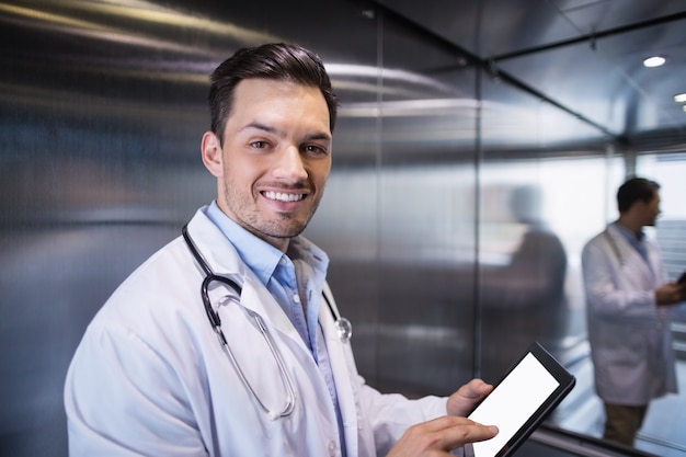 Portrait, de, docteur souriant, utilisation, tablette numérique, dans, couloir