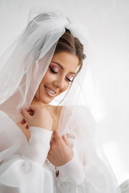 Photo portrait doux d'une jeune mariée avec un voile sur sa tête