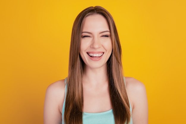 Portrait de drôle adorable jeune femme mignonne rayonnant sourire rire s'amuser sur fond jaune