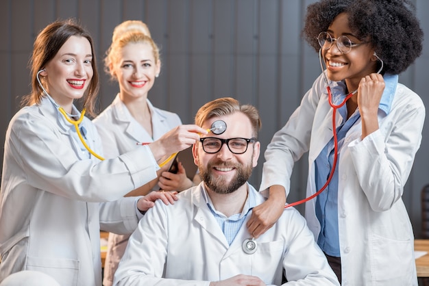 Portrait d'un drôle de groupe multiethnique de scientifiques médicaux ou d'étudiants assis ensemble au bureau ou en classe