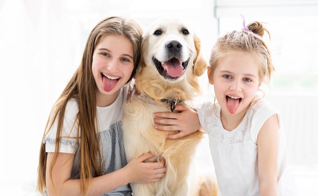 Portrait drôle de petites filles avec un chien mignon dans une pièce lumineuse