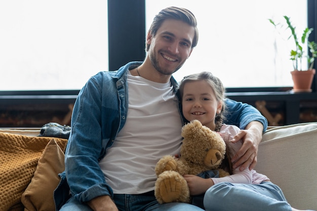 Portrait du beau père et de sa jolie fille étreignant et souriant.