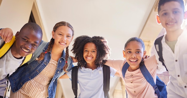 Portrait du cercle scolaire et des enfants pour le soutien de groupe à l'apprentissage et à l'éducation avec des amis de la diversité en plein air Bonne rentrée scolaire et connaissance des élèves ou des enfants avec un sac à dos dans un câlin