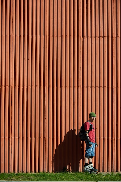 Le portrait du gars sur les rouleaux contre le mur rouge