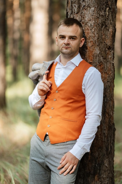 Portrait du marié en costume gris et gilet orange