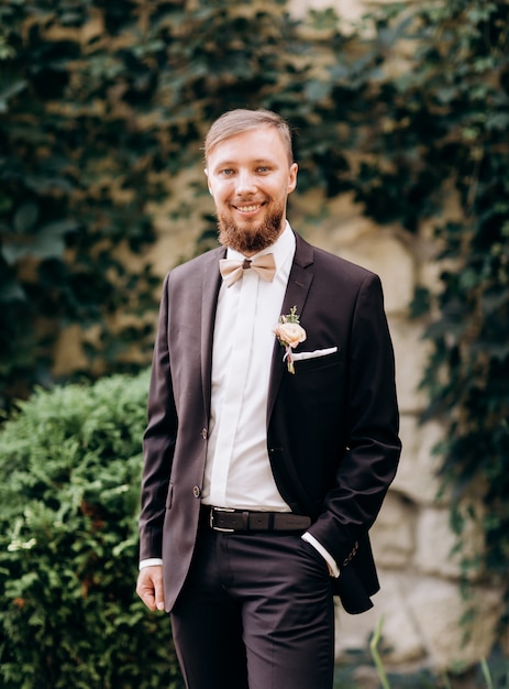 Portrait du marié élégamment vêtu. Beau marié avec barbe posant