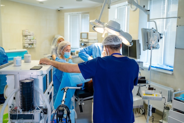 Portrait du médecin professionnel ou de l'assistant médical en masque chirurgical pendant l'opération. Salle d'opération de l'hôpital moderne.