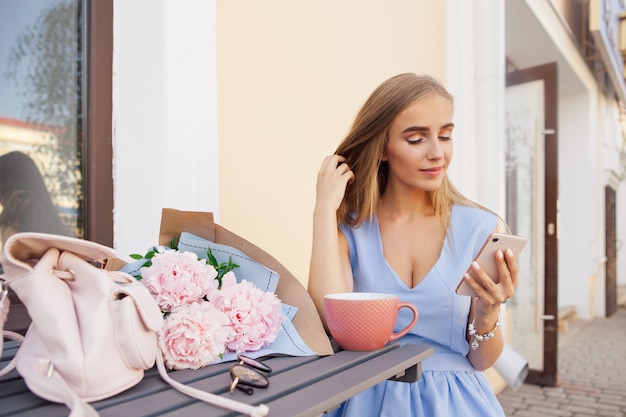 Portrait du message de textos des femmes branchées de la mode moderne par le smartphone