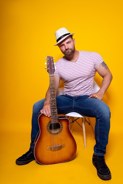 Photo portrait du musicien qui joue de la guitare acoustique et chante une chanson émotionnelle. célèbre barde