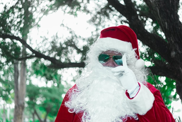 Portrait du père noël sur la lumière bokeh sous l'arbreThaïlandaisEnvoyé du bonheur pour les enfantsJoyeux NoëlBienvenue en hiver