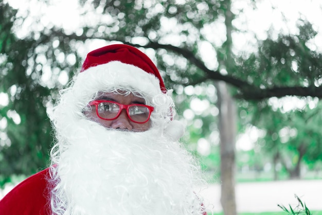 Portrait du père noël sur la lumière bokeh sous l'arbreThaïlandaisEnvoyé du bonheur pour les enfantsJoyeux NoëlBienvenue en hiver