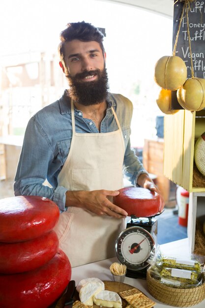 Portrait du personnel pesant le fromage gouda au comptoir