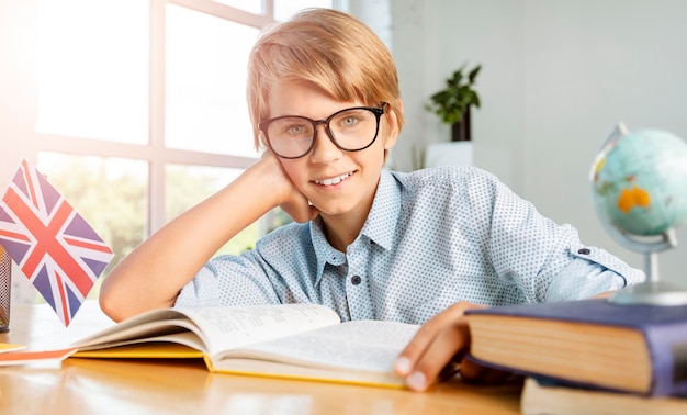 Portrait d'un écolier adolescent porte des lunettes intelligentes assis dans la salle de classe