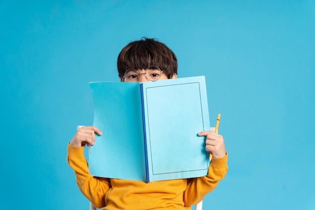 Portrait d'écolier asiatique né sur fond bleu