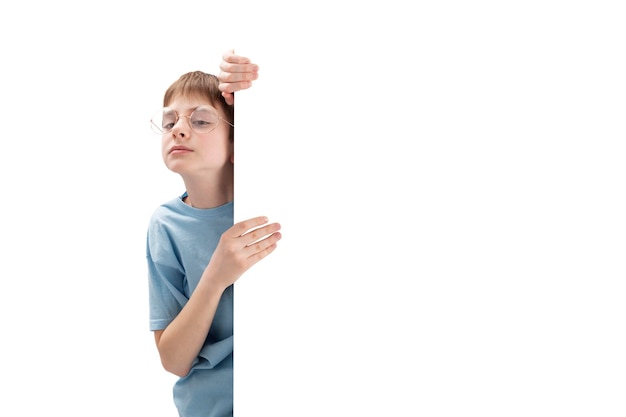 Portrait d'écolier dans de grands verres avec un espace vide dans les mains Enfant annonçant votre texte sur une affiche avec espace de copie Isolé sur fond blanc