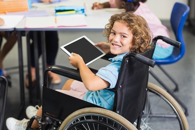 Photo portrait d'écolier handicapé à l'aide de tablette numérique