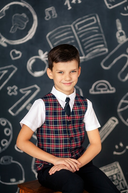 Photo portrait d'un écolier mignon heureux sur l'espace de tableau noir