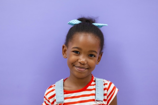 Portrait d'une écolière afro-américaine souriante sur un fond violet