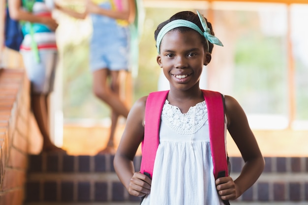 Photo portrait d'écolière debout dans le couloir de l'école