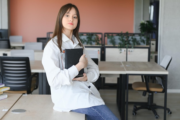 Portrait d'une écolière à l'école Elle tient des livres dans ses mains Concept de l'éducation