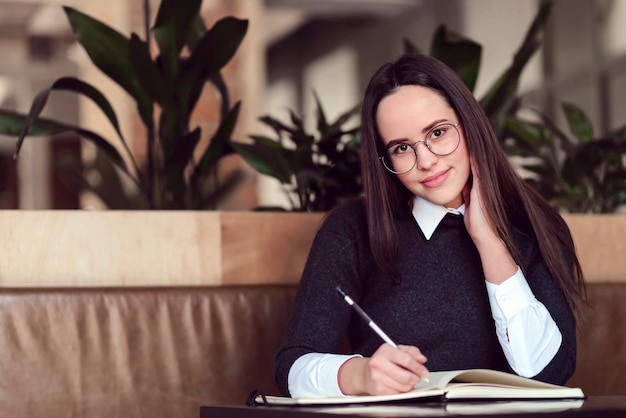 Portrait d'écolière étudiant à la cafétéria et faisant ses devoirs