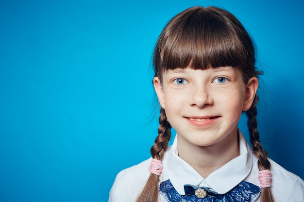 Portrait d&#39;une écolière sur fond bleu