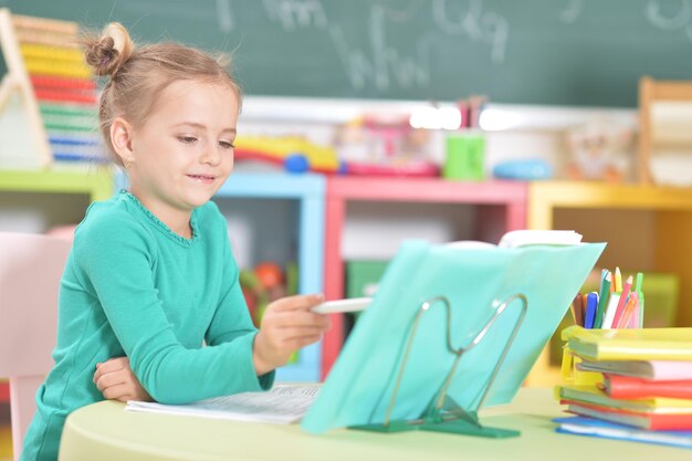 Portrait d'une écolière mignonne faisant ses devoirs