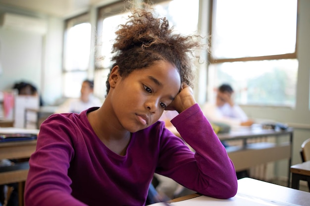 Portrait d'écolière se sentant triste et négligée par ses camarades de classe en classe