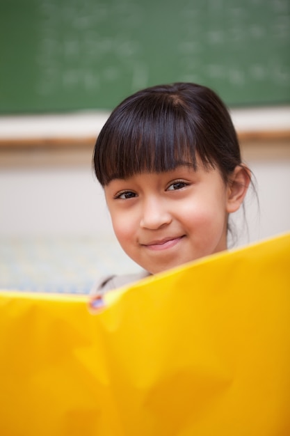 Portrait d&#39;une écolière souriante en train de lire