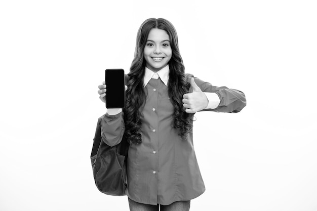 Portrait d'écolière tenant un téléphone isolé sur fond blanc