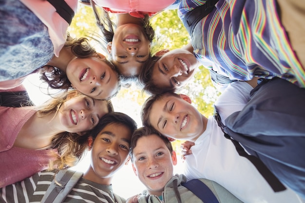 Portrait d'écoliers souriants formant une clique sur le campus