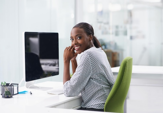 Portrait de l'écran d'ordinateur et sourire avec une femme noire au bureau dans le bureau pour l'administration de l'entreprise Afficher Internet et faire un rapport avec un jeune employé heureux au bureau sur le lieu de travail pour la recherche
