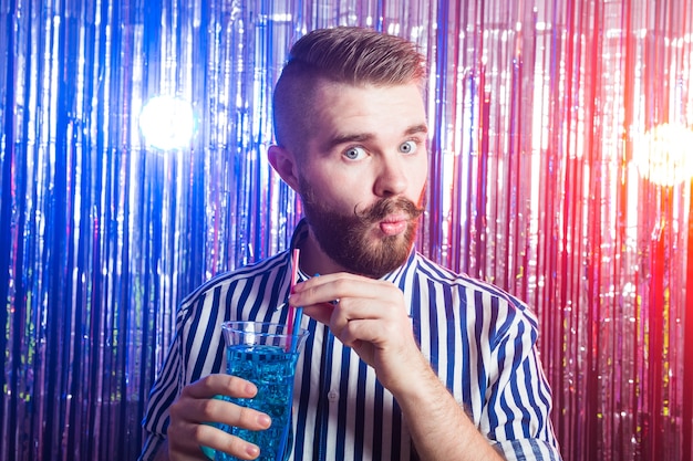 Portrait d'élégant bel homme buvant un cocktail