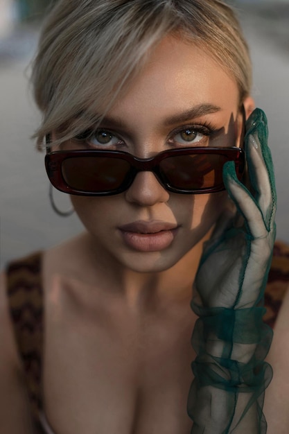 Portrait élégant d'une fille à lunettes et gants