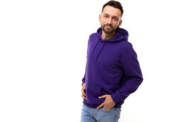 Portrait élégant d'un homme charismatique dans un sweat à capuche bleu violet sur fond blanc