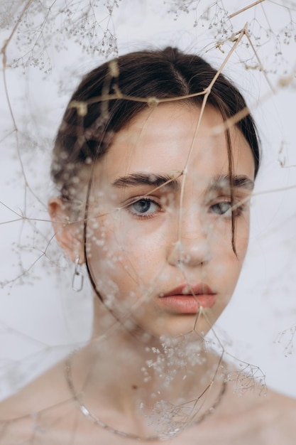 Portrait élégant d'une jeune fille avec des fleurs de gypsophile et une beauté naturelle de fille naturelle sans maquillage minimalisme et sophistication