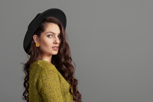 Portrait d'élégante belle femme au chapeau isolé sur fond gris