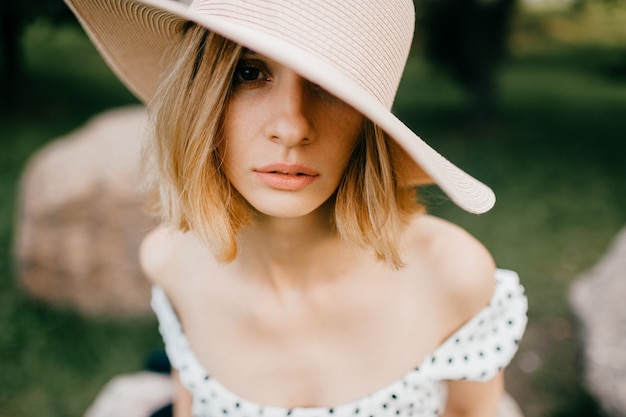 Portrait d'élégante élégante fille blonde cheveux courts en chapeau posant