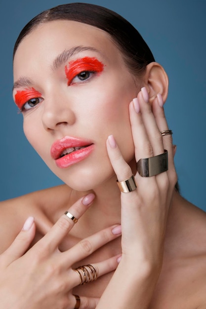 Portrait d'une élégante jeune femme au maquillage rouge vif sur fond bleu. Mode beauté