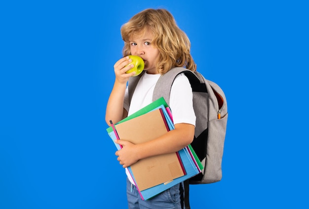 Portrait d'élève élève tenir un livre sur fond de studio isolé bleu concept d'école et d'éducation