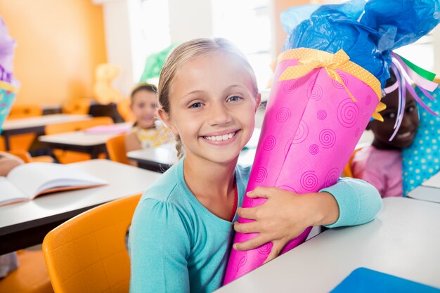 Portrait d'un élève souriant recevant une boîte-cadeau