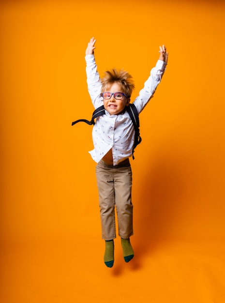 Portrait émotionnel d'un garçon avec des lunettes. Un enfant surpris regarde la caméra.