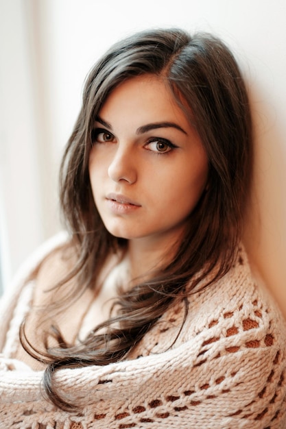 Photo portrait émotionnel en gros plan d'une belle jeune brune aux cheveux longs regardant la caméra