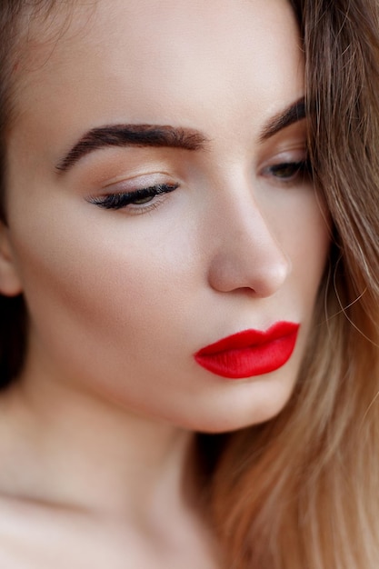 Portrait, émotions, personnes, concept de beauté - Femme de portrait de studio d'art de mode aux lèvres rouges. Rouge à lèvres à la mode. Cosmétique professionnelle. Portrait de la beauté en robe noire avec de grandes lèvres sexy.