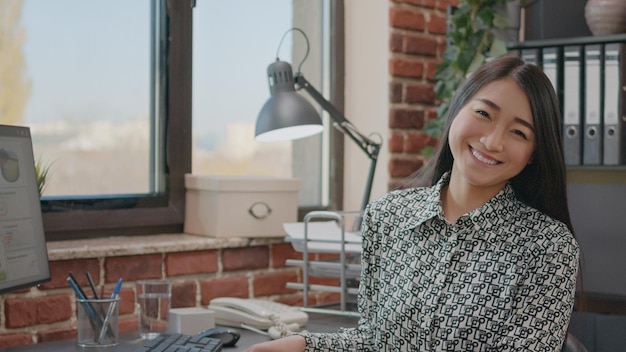 Portrait d'un employé de l'entreprise qui planifie un projet d'entreprise sur un ordinateur dans un bureau de démarrage. Femme travaillant sur la stratégie marketing et la croissance financière, à l'aide de graphiques de développement sur moniteur.