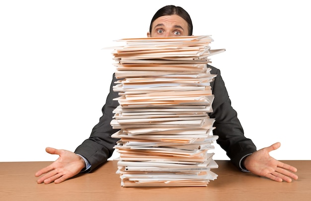 Photo portrait d'un employé surpris derrière une pile de documents