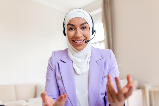 Portrait d'une employée d'origine ethnique confiante regardant la caméra parler par appel vidéo dans le bureau à domicile