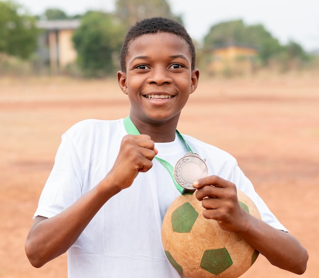 Photo portrait enfant africain avec ballon de football