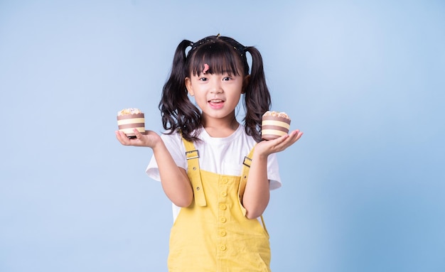 Portrait d'enfant asiatique posant sur fond bleu