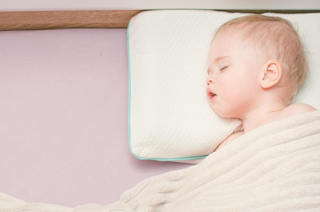 Portrait d'un enfant dormant dans un lit sur un oreiller Espace de copie